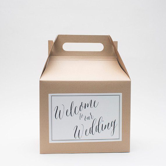 Cardboard wedding box with a handle, and a label saying welcome to our wedding in calligraphy.